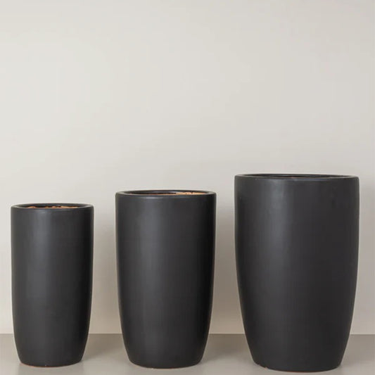 Tall black ceramic plant pots from Plant House, featuring sleek, modern design ideal for indoor or outdoor use.