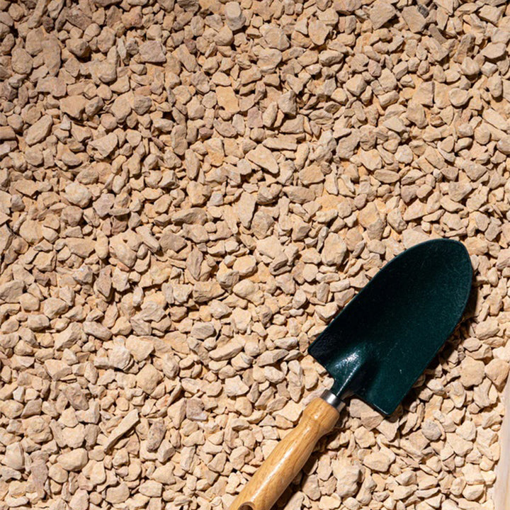 Beige gravel from Plant House, 20kg, suitable for plant landscaping, showing small 1-2cm stones on a garden surface.