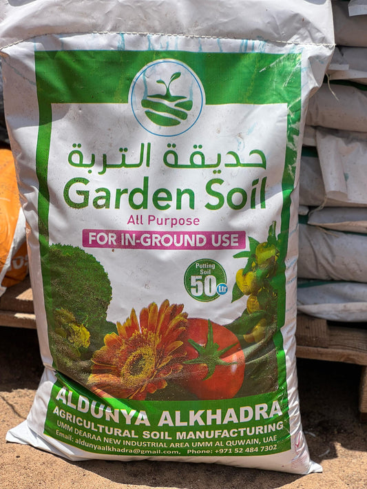 Organic potting soil for plants by Plant House, showing rich, dark soil in a garden setting with healthy green plants.