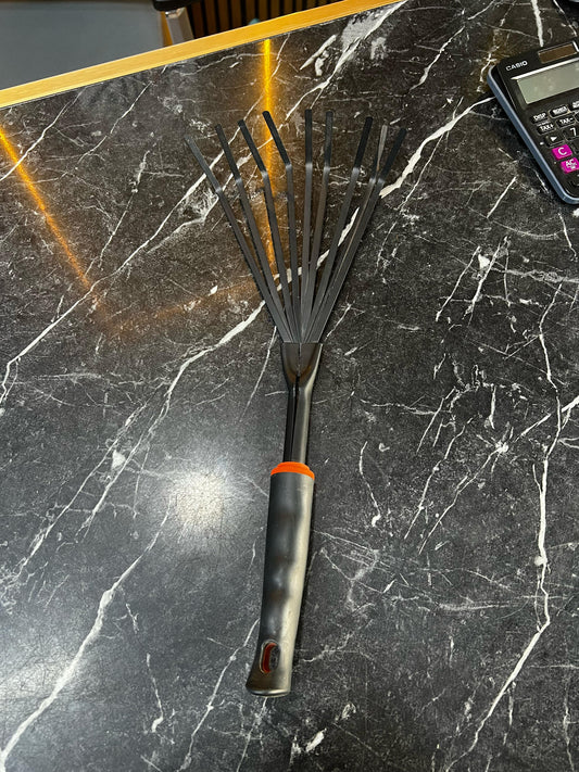 Garden hand rake by Plants House Gardening Work LLC, showing a sturdy metal tool with a wooden handle for gardening tasks.