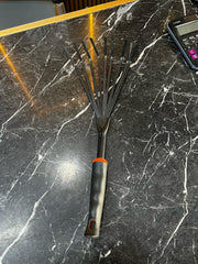 Garden hand rake tool by Plants House Gardening Work LLC, featuring metal tines for soil and weed removal.