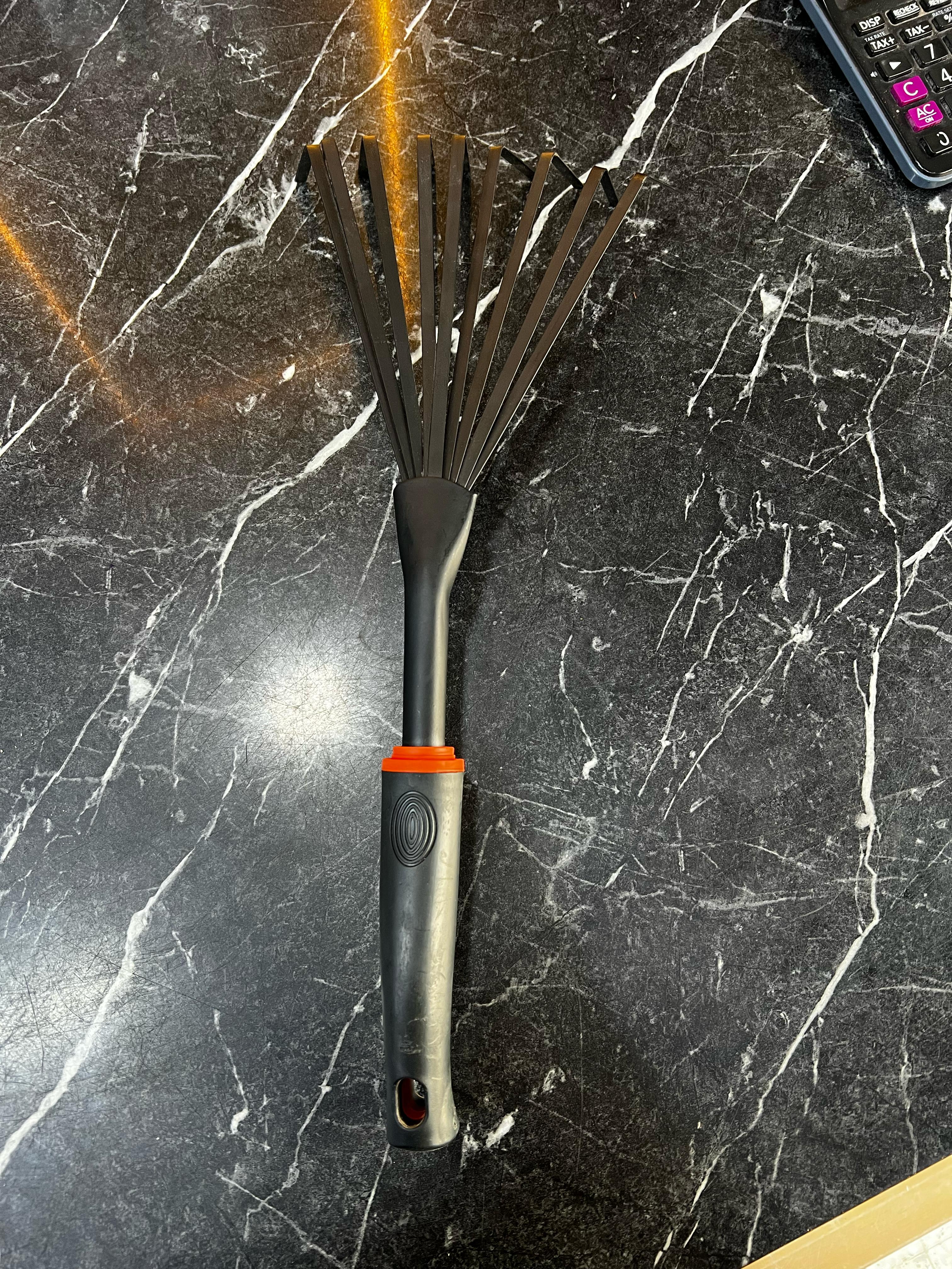 Garden hand rake from Plants House Gardening Work LLC, a durable tool for cultivating and loosening soil in the garden.